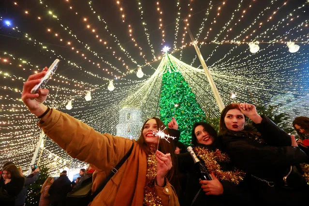 Revellers take part in New Year's Eve celebrations in Kyiv, Ukraine on December 31, 2020. (Photo by Valentyn Ogirenko/Reuters)