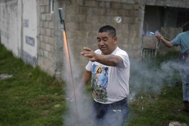 Genaro Santiago launches a firework in preparation of the arrival of St. Jude Thaddeus' relics to the church of San Cristobal Martir in San Cristobal Texcalucan, Mexico, Wednesday, August 7, 2024. (Photo by Eduardo Verdugo/AP Photo)
