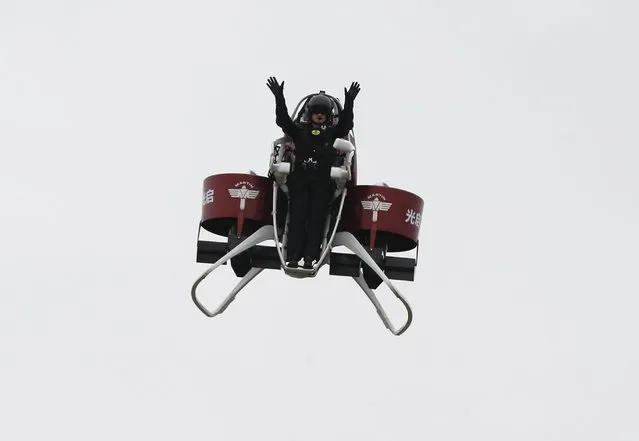Michael Read, Director of Flight Operations from New Zealand-based Martin Aircraft Company, waves to spectators while flying on a Martin Jetpack during a demonstration at a water park in Shenzhen, China December 6, 2015. (Photo by Bobby Yip/Reuters)