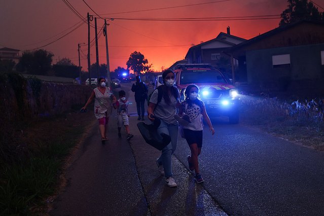 People leave their houses as a wildfire approaches, in Veiga, Agueda, Portugal, on September 17, 2024. (Photo by Pedro Nunes/Reuters)