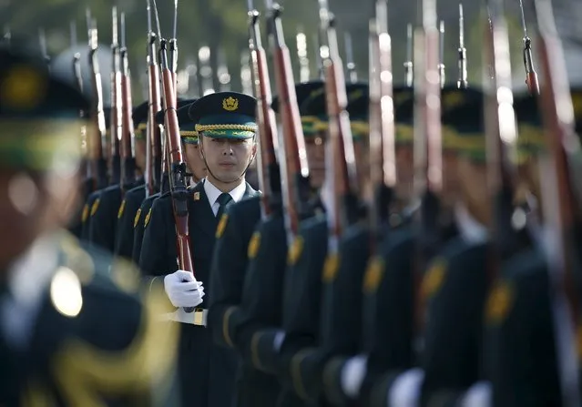 Members of Japan's Self-Defence Force's honour guard prepare for a ceremony for Prime Minister Shinzo Abe at the Defense Ministry in Tokyo December 16, 2015. (Photo by Issei Kato/Reuters)