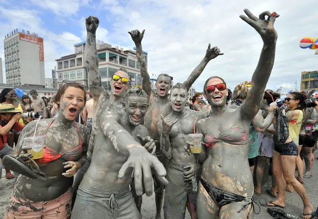 Tourists play with mud during the 16th Boryeong mud festival at Daecheon swimming beach in Boryeong, 150 kilometers southwest of Seoul, on July 20, 2013. The annual festival which runs from July 19-28 aims to encourage the use of mud for cosmetic skin-care and to promote tourism in the region. (Photo by Jung Yeon-Je/AFP Photo)