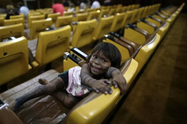 A Munduruku Indian child attends a meeting with the Secretariat-General of the Presidency of the Republic Miguel Rossetto at the Planalto Palace in Brasilia January 30, 2015. The Munduruku Indians are seeking to claim the right to be consulted regarding the construction of infrastructure projects within their territories. (Photo by Ueslei Marcelino/Reuters)
