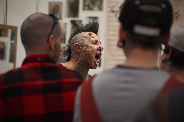 Pedrito Bodymod, 34, opens his mouth to shows a piercing on his uvula to a friend during a tattoo convention in the Andalusian capital of Seville February 14, 2015. (Photo by Marcelo del Pozo/Reuters)