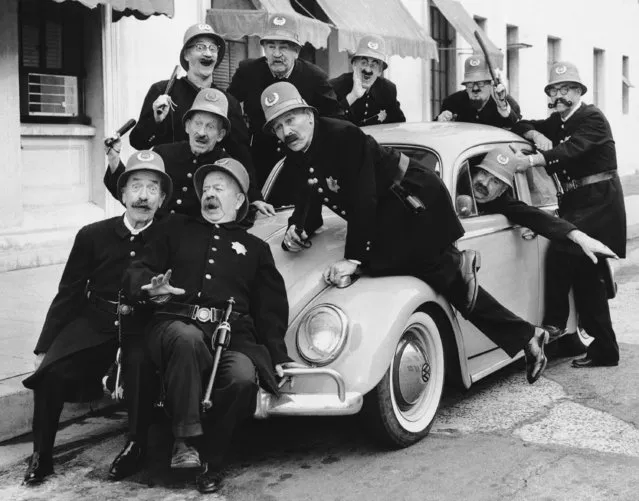 Eleven members of the famed Keystone Kops from the silent screen days show how they'd look in a modern car instead of a Model T Ford during their first reunion in uniform in Hollywood, Los Angeles on January 20, 1962, since they disbanded 30 years ago. In the group, from the front, are Billy Bledger, Chester Conklin, Clarence Hennecke, Glenn Cavender, Pinto Colvig, Tom Kennedy, Eddie Baker, John Grey, Del Lord, and, in the car, Ed LeVeque and Eddie Gribbon. (Photo by AP Photo)