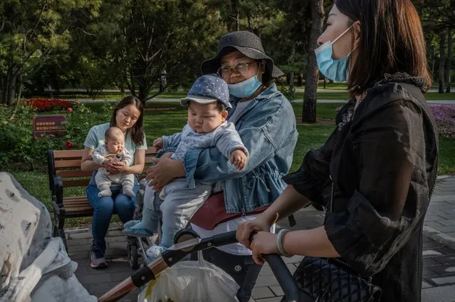 Women hold their babies as they talk at a local park on May 12, 2021 in Beijing, China. According to data released by the government from a national census, China's population grew 0.53 percent over the last 10 years down from 0.57 percent a decade ago bringing the population to 1.41 billion. (Photo by Kevin Frayer/Getty Images)