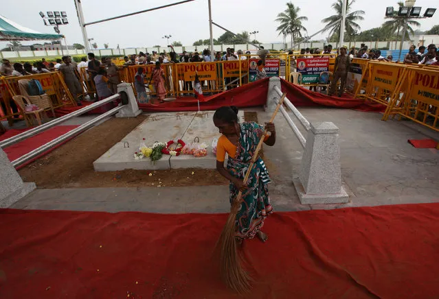 A woman cleans the floor at the burial site of Tamil Nadu Chief Minister Jayalalithaa Jayaraman in Chennai, India December 7, 2016. (Photo by Adnan Abidi/Reuters)