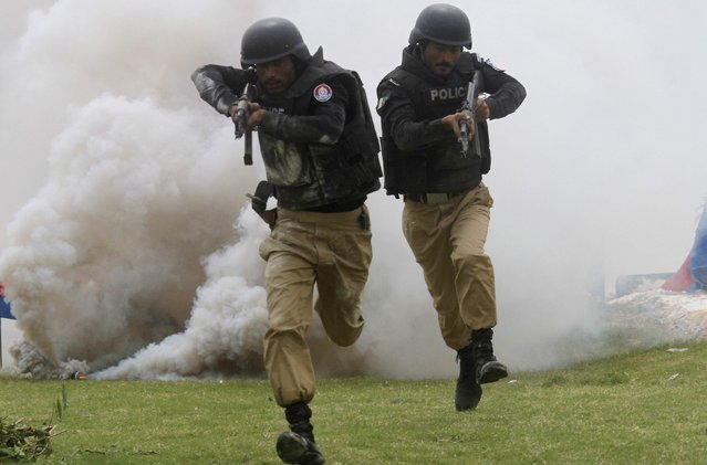 Cadets display their skills during a passing out parade, upon the completion of their basic training at the Police Training College, on the outskirts of Karachi, March 13, 2015. Some 510 cadets successfully completed their basic training at the Police Training College in Karachi, according to the college. (Photo by Athar Hussain/Reuters)