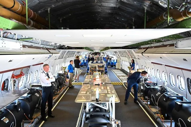 Visitors looks at water barrels  placed in a Boeing 777X for an experiment on weight distribution during the Farnborough Airshow, in Farnborough. (Photo by Justin Tallis/AFP Photo)