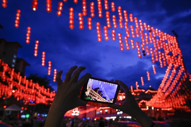 A Malaysian ethnic Chinese woman takes a souvenir photograph of illuminated traditional Chinese lanterns on the eve of Lunar New Year in Kuala Lumpur, Malaysia, Sunday, February 7, 2016. (Photo by Joshua Paul/AP Photo)