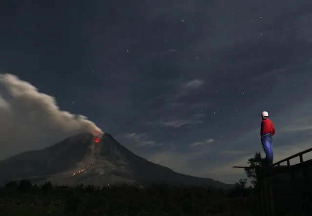 A man looks at Mount Sinabung spewing ash from Jraya village in Karo district, January 13, 2014. (Photo by Roni Bintang/Reuters)