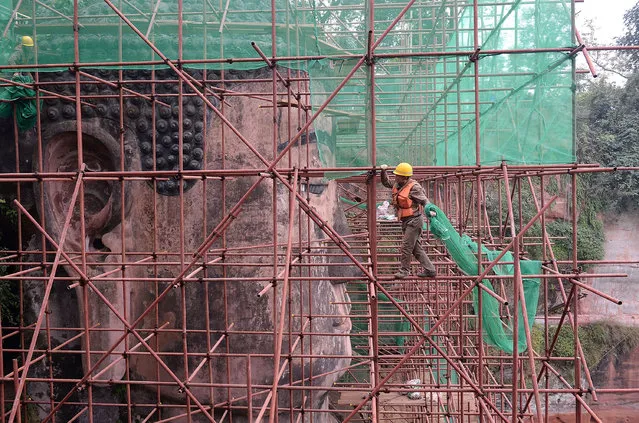 The Leshan Giant Buddha is covered with scaffolding for a restoration project to fix large cracks across its chest and abdomen in Leshan city, Sichuan province, China on December 13, 2018. (Photo by Imaginechina/Rex Features/Shutterstock)