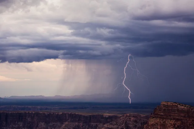 A bolt from a summer thunderstorm drops just on the north side of the Little Colorado River, seen from the Grand Canyon in Navajo Point, Arizona, 23 August 2016. (Photo by Mike Olbinski/Barcroft Images)