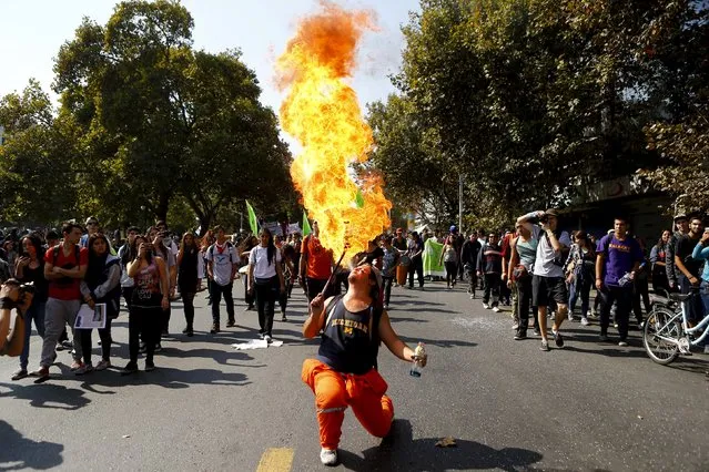 A protester breathes fire during a demonstration against the government to demand changes in the education system at Santiago, April 16, 2015. (Photo by Ivan Alvarado/Reuters)