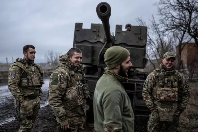 Service members of Ukrainian Joint Assault Brigade Fury stand next to an S60 cannon near the frontline town of Bakhmut, Donetsk region, Ukraine on December 21, 2023. (Photo by Viacheslav Ratynskyi/Reuters)