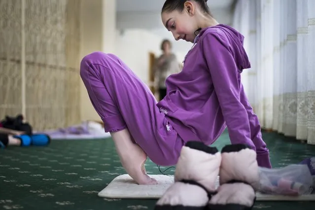 In this photo taken on Thursday, March  3, 2016, Harper Ortlieb, from Mount Hood, Oregon, stretches in a ballet class at the Bolshoi Ballet Academy in Moscow, Russia. (Photo by Alexander Zemlianichenko/AP Photo)