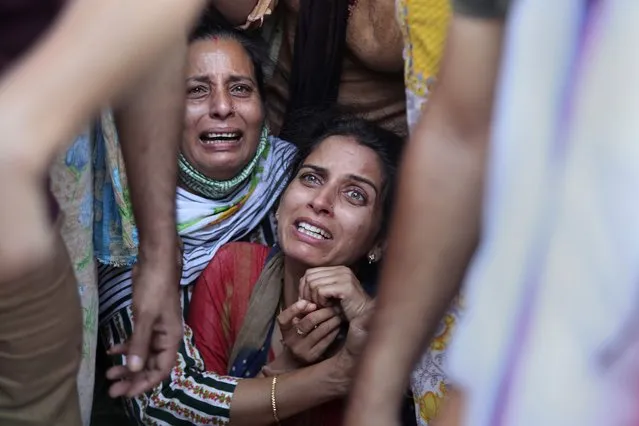 Aradhana, center, wife of Deepak chand, a school teacher who was killed in Kashmir, mourns before the cremation in Jammu, India, Friday, October 8, 2021. Assailants fatally shot two schoolteachers in Indian-controlled Kashmir on Thursday in a sudden rise in targeted killings of civilians in the disputed region, police said. Authorities blamed militants fighting against Indian rule for the attack in the outskirts of Srinagar, the region’s main city. (Photo by Channi Anand/AP Photo)