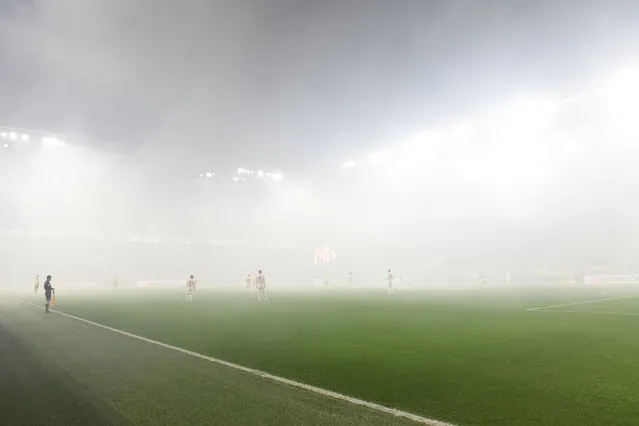 Fog due to light flares is seen on the pitch prior the start of the German first division Bundesliga football match between BVB Borussia Dortmund and Mainz 05 in Dortmund, western Germany on December 19, 2023. (Photo by Uwe Kraft/AFP Photo)