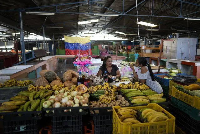 Produce vendors wait for customers at a market in Caracas, Venezuela, Friday, October 1, 2021. A new currency with six fewer zeros debuts today in Venezuela, whose currency has been made nearly worthless by years of the world's worst inflation. The new currency tops out at 100 bolivars, a little less than $25 until inflation starts to eat away at that as well. (Photo by Ariana Cubillos/AP Photo)