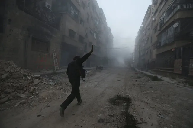 A rebel fighter gestures as he runs across a street in Mleha suburb of Damascus, during what the rebel fighters said was an offensive against them by forces loyal to Syria's President Bashar al-Assad, April 2, 2014. (Photo by Bassam Khabieh/Reuters)