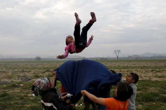 Children play at a makeshift camp for migrants and refugees at the Greek-Macedonian border near the village of Idomeni, Greece, March 29, 2016. (Photo by Marko Djurica/Reuters)