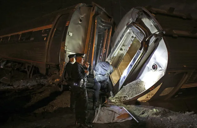 Emergency personnel work the scene of a train wreck, Tuesday, May 12, 2015, in Philadelphia. An Amtrak train headed to New York City derailed and crashed in Philadelphia. (Photo by Joseph Kaczmarek/AP Photo)