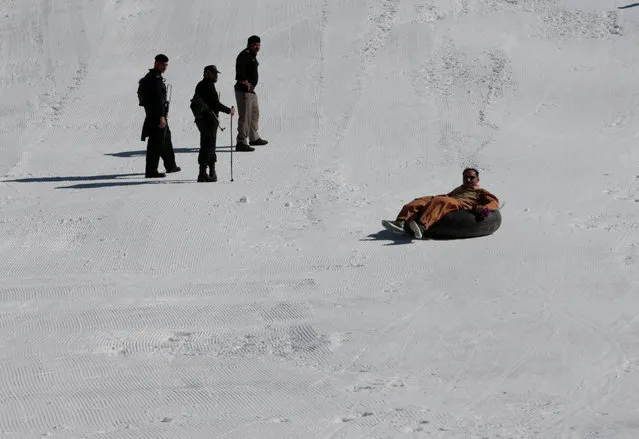 Policemen watch as a man rides an inner tube on the piste at the ski resort in Malam Jabba, Pakistan February 7, 2017. (Photo by Caren Firouz/Reuters)