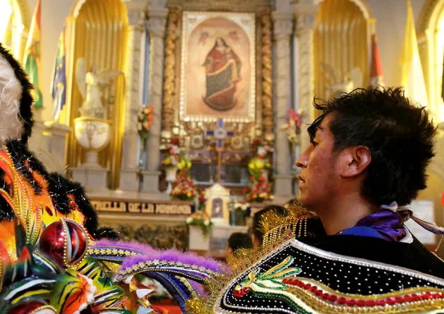 A member of the Diablada group passes in front of the image of the Virgin of Candelaria after the carnival parade in Oruro, Bolivia February 25, 2017. (Photo by David Mercado/Reuters)