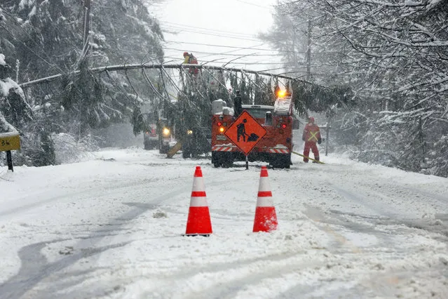 A portion of Route 9 between Falmouth and Cumberland is closed as crews work to remove a downed tree spanning the snow-covered roadway in Falmouth, Maine, Thursday, April 4, 2024, following a spring snowstorm. (Photo by Ben McCanna/Portland Press Herald via AP Photo)