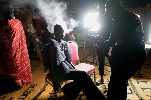 A model prepares backstage before a show of the 19th annual Dakar Fashion Week, at the Baobad forest, in Mbour, Senegal, December 18, 2021. (Photo by Zohra Bensemra/Reuters)