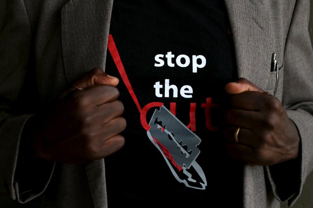 A man shows the logo of a T-shirt that reads “Stop the Cut” referring to Female Genital Mutilation (FGM) during a social event advocating against harmful practices such as FGM at the Imbirikani Girls High School in Imbirikani, Kenya, April 21, 2016. (Photo by Siegfried Modola/Reuters)