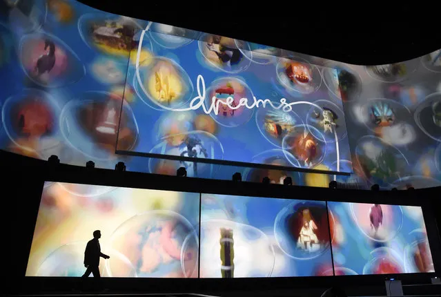 Asad Qizilbash, head of software marketing for Sony Computer Entertainment America, walks out onstage as graphics from the video game "Dreams" are displayed during the Sony Playstation at E3 2015 news conference at the Los Angeles Sports Arena on Monday, June 15, 2015, in Los Angeles. (Photo by Chris Pizzello/Invision/AP)