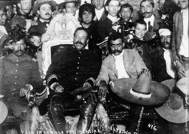 Mexican revolutionary leaders Emiliano Zapata (C, Left) (1879 - 1919) and Pancho Villa (1878 - 1923) (C, Right) sit in front of a group of soldiers, January 2, 1915