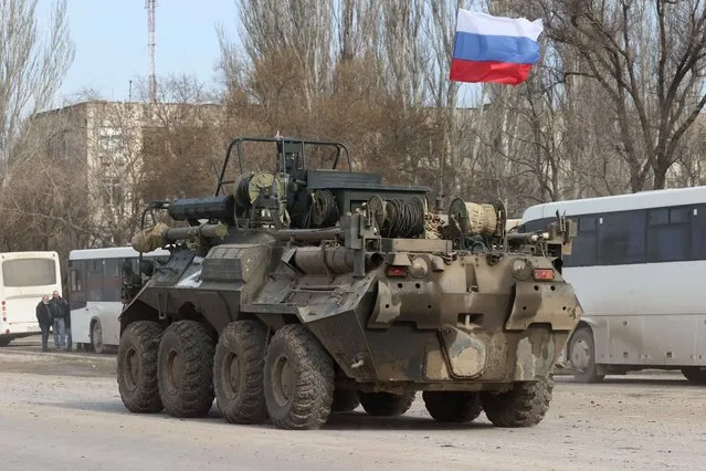 An armoured vehicle moves across the town of Armyansk, northern Crimea, Russia on February 24, 2022. Early on February 24, President Putin announced a special military operation to be conducted by the Russian Armed Forces in response to appeals for help from the leaders of the Donetsk and Lugansk People's Republics. (Photo by Sergei Malgavko/TASS)