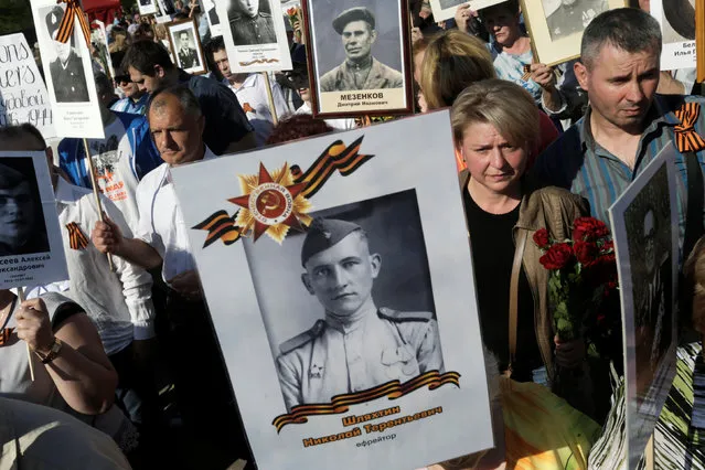 People hold pictures of World War Two soldiers as they take part in the Immortal Regiment march during the Victory Day celebrations in Riga, Latvia May 9, 2016. (Photo by Ints Kalnins/Reuters)