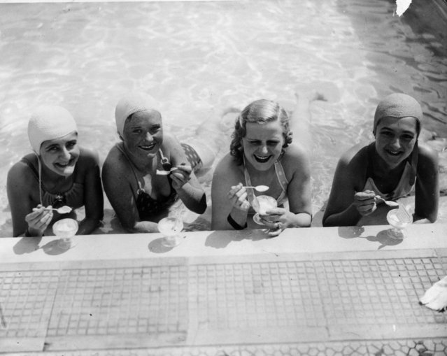 Four swimmers enjoy an ice-cream at the water's edge in Roehampton swimming pool, UK, 23rd May 1936. (Photo by Reg Speller/Fox Photos/Getty Images)