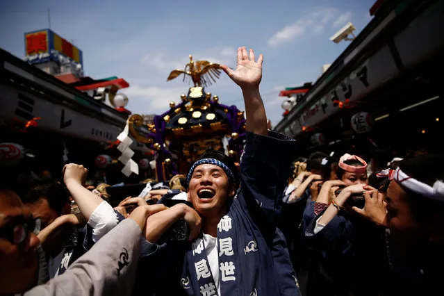 People carry a portable shrine, a Mikoshi, near the Senso-ji Temple during the Sanja festival in Tokyo's Asakusa district, Japan, May 15, 2016. (Photo by Thomas Peter/Reuters)