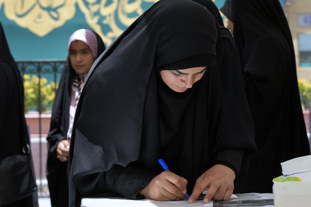 A woman fills out her ballot during the Iranian presidential election in a polling station at the shrine of Saint Saleh in northern Tehran, Iran, Friday, June 28, 2024. Iranians were voting Friday in a snap election to replace the late President Ebrahim Raisi, killed in a helicopter crash last month, as public apathy has become pervasive in the Islamic Republic after years of economic woes, mass protests and tensions in the Middle East. (Photo by Vahid Salemi/AP Photo)