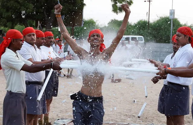 Members of Bajrang Dal, youth wing of hardline Vishwa Hindu Parishad (VHP), show their skills at the concluding ceremony of a weeklong self-defence training camp on the outskirts of Ahmedabad, India May 22, 2016. (Photo by Amit Dave/Reuters)