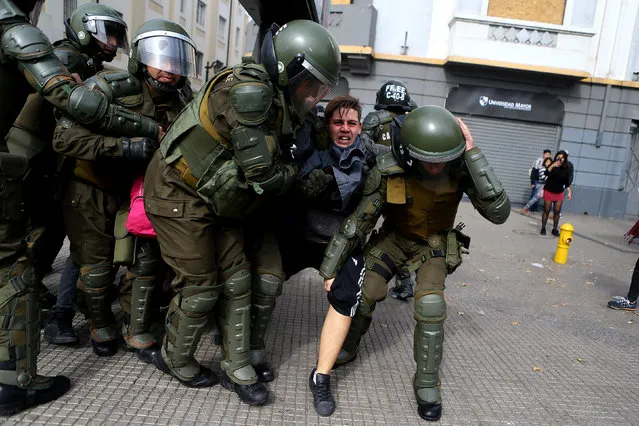 A demonstrator is detained during clashes with riot police at a students' march for a better education reform in Santiago, Chile on May 9, 2017. (Photo by Ivan Alvarado/Reuters)