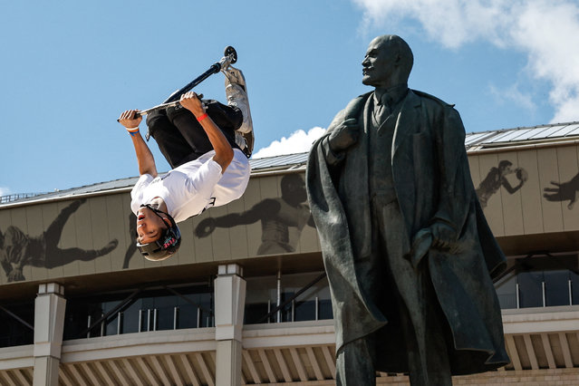 A rider performs a scooter trick next to a statue of the Soviet state founder Vladimir Lenin during the Moscow Sports Day festival at the Luzhniki Olympic Complex, in Moscow, Russia on July 6, 2024. (Photo by Evgenia Novozhenina/Reuters)