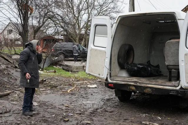 A relative cries as a body of a civilian killed in a Russian air raid at the beginning of the Russia-Ukraine war, was loaded on a van in Borodyanka close to Kyiv, Ukraine, Saturday, Apr. 9, 2022. (Photo by Efrem Lukatsky/AP Photo)