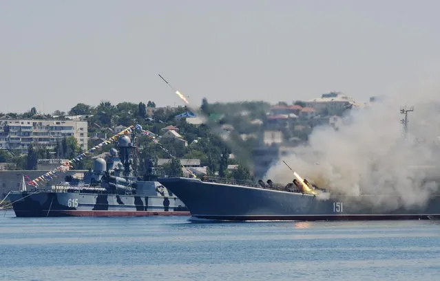 Missiles are fired by a Russian navy battle ship during a rehearsal of the Russian Navy Day parade in Sevastopol, Crimea, Friday, July 24, 2015. (Photo by Alexander Polegenko/AP Photo)