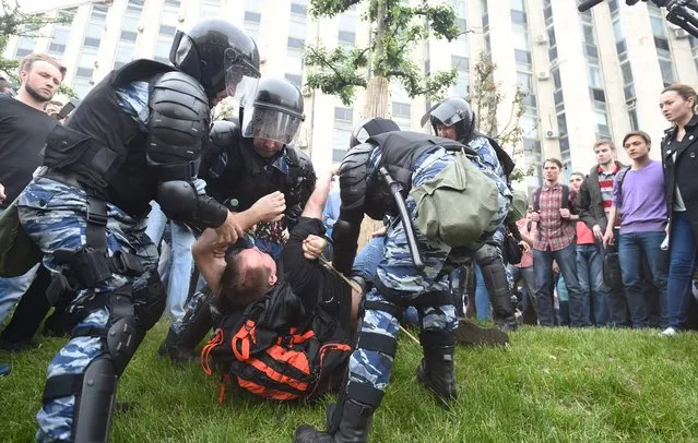 Russian police officers detain a participant of an unauthorized opposition rally in Tverskaya street in central Moscow on June 12, 2017. (Photo by AFP Photo/Stringer)