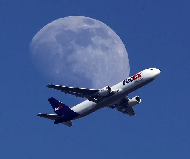 A Fed Ex cargo airplane passes over Whittier, Calif., on its way to Los Angeles International Airport, Sunday, July 26, 2015. (Photo by Nick Ut/AP Photo)