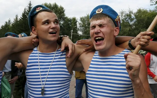 Men sing during the celebrations for the Paratroopers Day at the Central park in the Siberian city of Krasnoyarsk, Russia, August 2, 2015. The holiday, which marks the 85th anniversary of the foundation of state paratroopers troops, has been annually celebrated since the Soviet era till today. (Photo by Ilya Naymushin/Reuters)