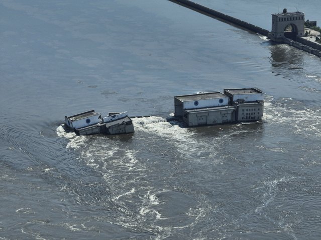 Water flows over the collapsed Kakhovka dam in Nova Kakhovka, in Russian-occupied Ukraine, Wednesday, June 7, 2023. Thousands of people are believed to be trapped by floodwaters spread across a swath of Ukraine after a catastrophic dam collapse. (Photo by AP Photo)