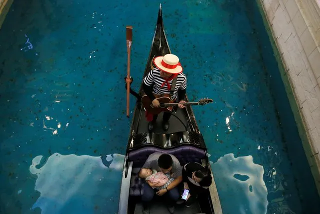 A boy sleeps as the family take a gondola ride inside the shopping mall of the Venetian Macao hotel and casino in Macau, China December 19, 2019, on the eve of the 20th anniversary of the former Portuguese colony's return to China. (Photo by Jason Lee/Reuters)