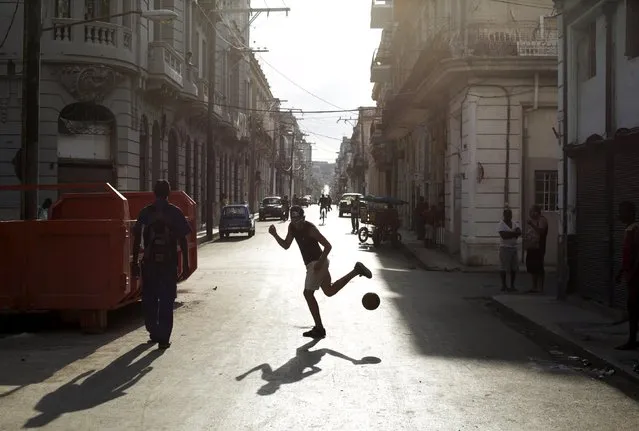 A young man plays soccer on a street in Havana April 10, 2015. (Photo by Enrique De La Osa/Reuters)