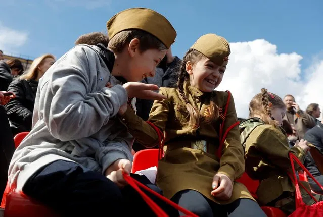 Girls wearing the Red Army styled uniform react after a military parade on Victory Day, which marks the 77th anniversary of the victory over Nazi Germany in World War Two, in Red Square in central Moscow, Russia on May 9, 2022. (Photo by Maxim Shemetov/Reuters)
